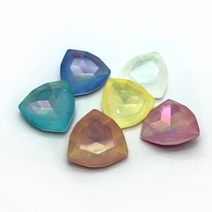 Op de afbeelding: Zes regenboogkleurige glazen cabochons in druppelvorm in verschillende kleuren, waaronder blauw, groen, geel, roze en wit.