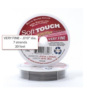 May include: Two spools of Soft Touch Very Fine wire for stringing gemstones, embellishing, weaving, and crocheting. The wire is satin silver color, 0.010" diameter, and 30 feet long. The packaging includes the text "Soft Flex Premium Flex Wire".
