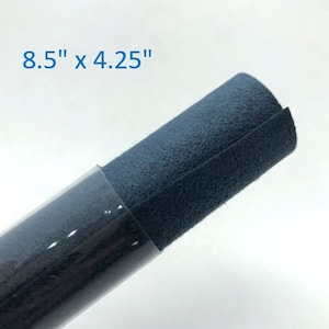 May include: A rolled up piece of dark blue suede fabric, measuring 8.5 inches by 4.25 inches.