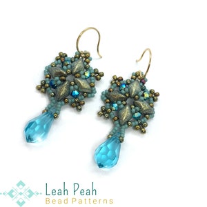 Puede incluir: Un par de pendientes de copo de nieve de cuentas de color turquesa y dorado con un colgante de cristal en forma de lágrima. Los pendientes están hechos a mano y presentan un diseño delicado.