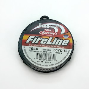 Peut inclure: Une bobine de fil à perles tressé microfusionné FireLine noir de Berkley. La bobine est étiquetée avec le texte "10LB Smoke 50YD" et "0.008in avg.dia FLBT10-42 1889712".