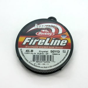 May include: A spool of black FireLine microfused braided bead thread by Berkley Beadsmith. The spool is labeled with the text "4LB Crystal 50YD 0.005in avg.dia FLBT4-CY 1389514 90524 46534 F-28-23-1".