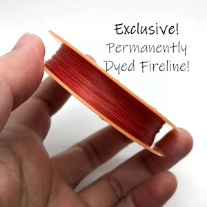 May include: A spool of red fishing line, permanently dyed, on a beige plastic spool. The text "Exclusive! Permanently Dyed Fireline!" is written in black above the spool.