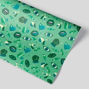 May include: Green wrapping paper with a repeating pattern of eyes, lips, hearts, potion bottles, and crystal balls. The background is a light green with white stars.