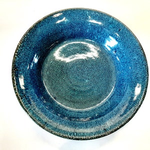 May include: A large, round, blue and green ceramic serving bowl with a speckled glaze.
