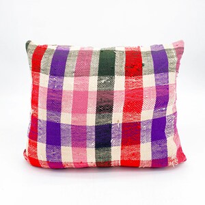 May include: A square pillow with a red, pink, purple, and green plaid pattern.