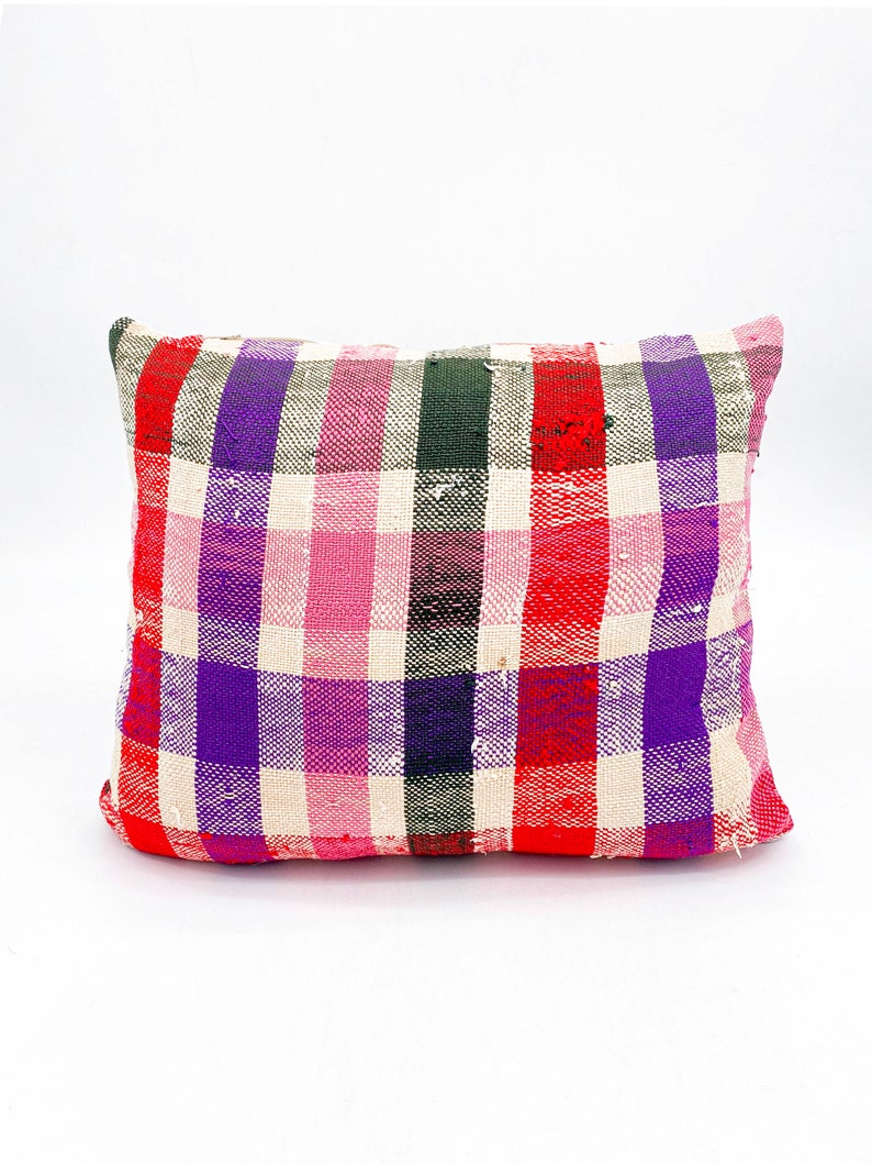 May include: A square pillow with a red, pink, purple, and green plaid pattern.