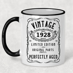 May include: White ceramic mug with a black handle and black rim. The mug has a vintage design with the text "Vintage Finest 1928 Quality Limited Edition Original Parts (Mostly) Perfectly Aged".