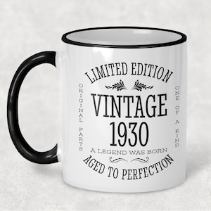 May include: White ceramic coffee mug with a black rim and handle. The mug has black text that reads "Limited Edition Vintage 1930 A Legend Was Born Aged To Perfection One Of A Kind Original Parts".