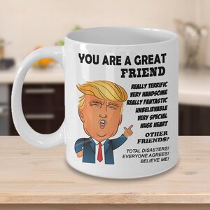 May include: White ceramic coffee mug with a cartoon image of Donald Trump. The mug reads "You are a great friend. Really terrific, very handsome, really fantastic, unbelievable, very special, huge heart. Other friends? Total disasters! Everyone agrees! Believe me!"