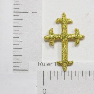 May include: A gold embroidered cross with a simple design. The cross is about 1 inch in size.