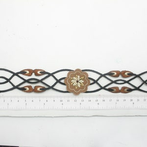 Può includere: Un bordino ricamato nero e marrone con tre accenti floreali decorativi. Il bordino è lungo circa 27 pollici.