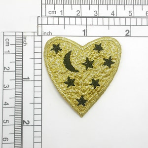 Può includere: Toppa a forma di cuore dorata con una mezzaluna nera e stelle ricamate.
