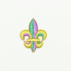 May include: An embroidered fleur-de-lis patch in gold, green and purple.