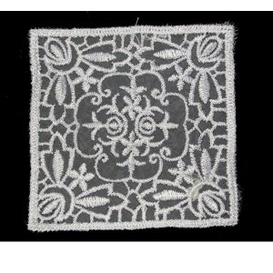 May include: White lace doily with a floral design. The doily is square and has a delicate, intricate pattern.