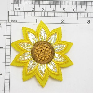 May include: A yellow embroidered sunflower patch with a brown center and silver accents. The patch is approximately 2 inches in diameter.