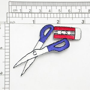 May include: An embroidered patch featuring a pair of blue scissors and a red and white eraser with the word "Erase" written on it.