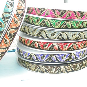 May include: A stack of colorful trim with a gold leaf and swirl design. The trim is on a white surface.