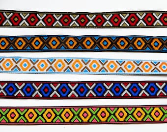 May include: Close-up of six colorful woven ribbons with geometric patterns. The ribbons feature various color combinations, including red, blue, orange, and green, with white and black accents. The ribbons are displayed against a white background.