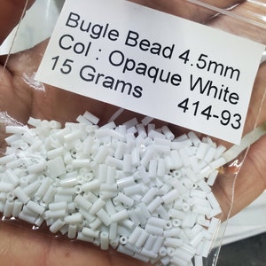 May include: A bag of white opaque bugle beads, 4.5mm in size, weighing 15 grams. The label reads "Bugle Bead 4.5mm Col: Opaque White 15 Grams 414-93".