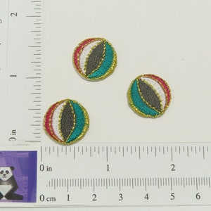 Puede incluir: Tres parches bordados para planchar en forma de pelotas de playa. Las pelotas de playa son rojas, blancas, grises, azul verdoso y doradas.