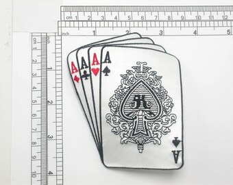 May include: A white embroidered patch with four playing cards showing the Ace of Spades, Ace of Hearts, Ace of Diamonds, and Ace of Clubs. The Ace of Spades is the largest card and features an ornate design.