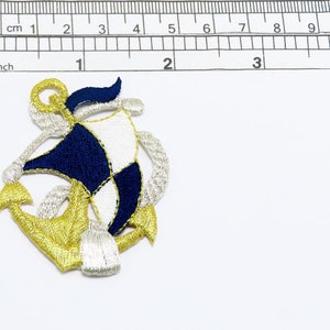 May include: A gold, white, and blue embroidered anchor patch. The anchor is surrounded by a white rope design.