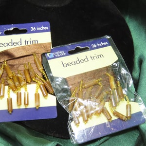 May include: Two packages of brown beaded trim, each 36 inches long, with the text "Crafters Square" and "beaded trim" on the packaging.