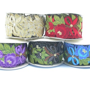 May include: Five spools of embroidered trim with floral designs. The trims are in gold, red, purple, black, and blue.