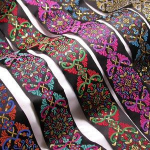 May include: Assortment of black ribbon trim with colourful embroidered floral designs. The trim features gold, pink, blue, green, and red accents.