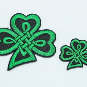 May include: Two green embroidered shamrock patches with black outlines and Celtic knot designs. The larger patch is about 3 inches wide and the smaller patch is about 1.5 inches wide.