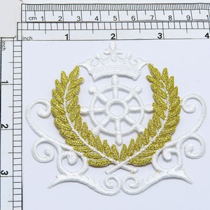 Könnte beinhalten: Weißer gestickter Aufnäher mit einem goldenen Glitzerkranz, einem weißen Rad und einer weißen Krone. Der Aufnäher hat einen Durchmesser von etwa 5 cm.
