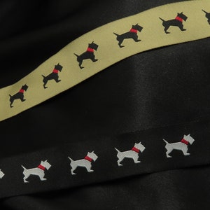 May include: Two rolls of black and beige ribbon with a repeating pattern of black and white silhouette dogs wearing red collars.