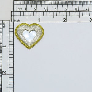 May include: A gold and silver heart-shaped patch with a mirror in the center. The patch is about 1.5 inches wide.