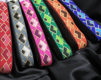 May include: Assortment of colorful ribbon trim with a geometric diamond pattern. The ribbon trim is made of a woven fabric with gold thread accents.