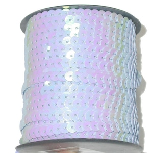May include: A spool of iridescent light blue sequins, perfect for adding sparkle to crafts and clothing.