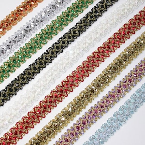 May include: Assortment of colorful sequined trim with a zig-zag pattern. The trim is available in silver, green, black, red, gold, purple, and blue.