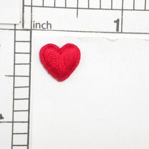 May include: A small, red felt heart-shaped patch. The patch is about 1 inch in diameter.