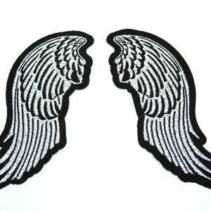 May include: A pair of black iron-on patches with silver embroidered angel wings.