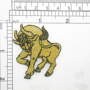 May include: Gold embroidered iron-on patch of a bull with black outlines. The bull is facing right and has a raised head.