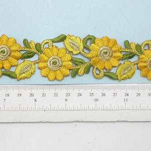 Può includere: Bordatura ricamata gialla con un motivo floreale con girasoli e foglie. La bordatura è larga circa 2,5 cm.