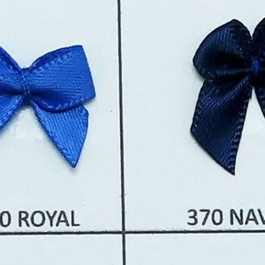May include: A color chart of satin ribbon bows in various colors, including turquoise, jade, teal, royal blue, navy, light orchid, grape, and purple. Each bow is labeled with its corresponding color code.