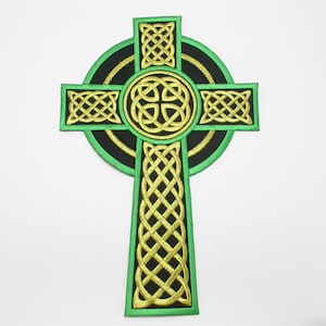 May include: A green and gold Celtic cross embroidered patch. The cross is surrounded by a circle with a Celtic knot design.