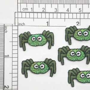May include: Five green felt spider appliques with white eyes. Each spider is approximately 1 inch in diameter.
