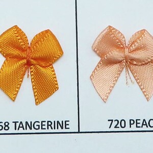 May include: A sample card of ten different colors of satin ribbon bows. The colors are spruce, lemon, daffodil, tangerine, peach, copper, buttermilk, and raw silk.