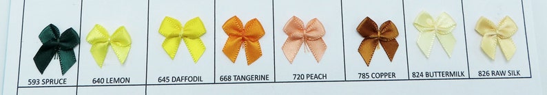 May include: A sample card of ten different colors of satin ribbon bows. The colors are spruce, lemon, daffodil, tangerine, peach, copper, buttermilk, and raw silk.