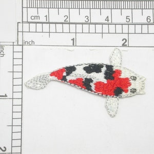 May include: Embroidered iron-on patch of a red, black, and white koi fish. The fish is about 2 inches long.