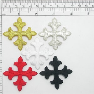 Könnte beinhalten: Fünf gestickte Kreuz-Applikationen in Gold, Silber, Weiß, Rot und Schwarz. Jedes Kreuz hat ein detailliertes, verziertes Design. Die Applikationen sind etwa 3,8 cm groß und eignen sich für verschiedene Bastelprojekte.
