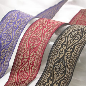 May include: Three decorative trim ribbons with a beige background and intricate black, purple, and red patterns.
