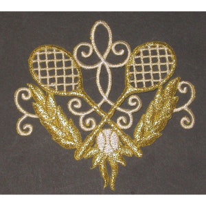 May include: Gold and white embroidered design of two crossed tennis rackets with a tennis ball in the centre. The rackets are surrounded by ornate swirls.